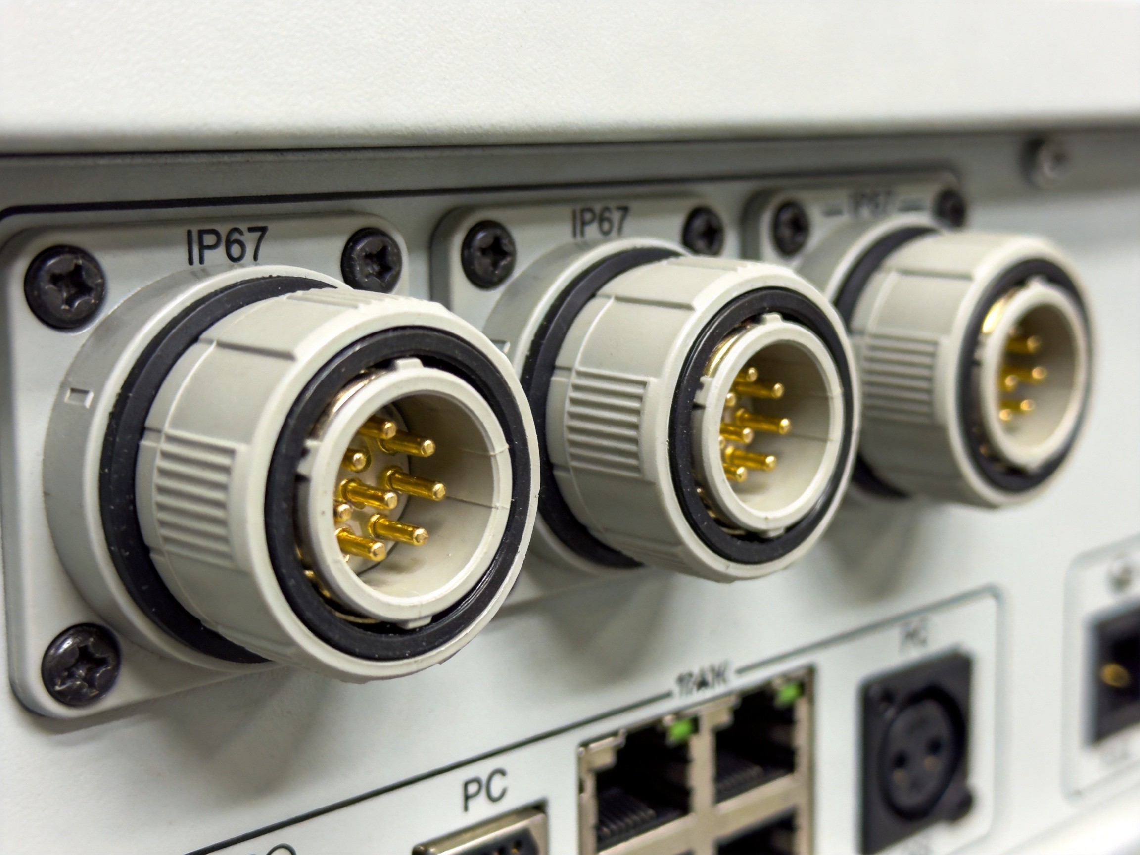 Industrial circular connectors with gold-plated contacts and IP67-rated sealing on a panel PC I/O panel