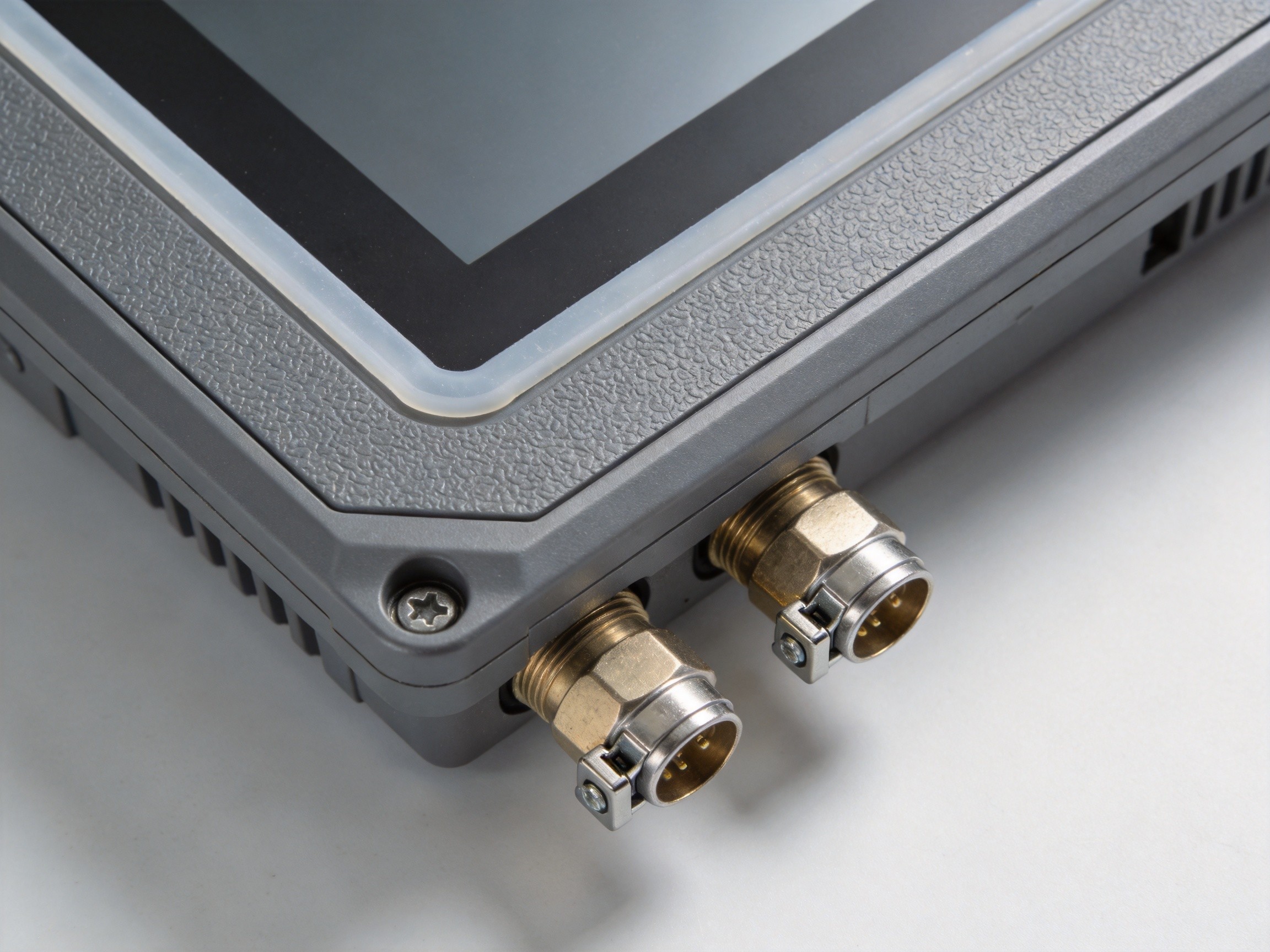 Close-up of an industrial panel PC front bezel with silicone gasket seal and IP65-rated cable glands showing water-tight construction