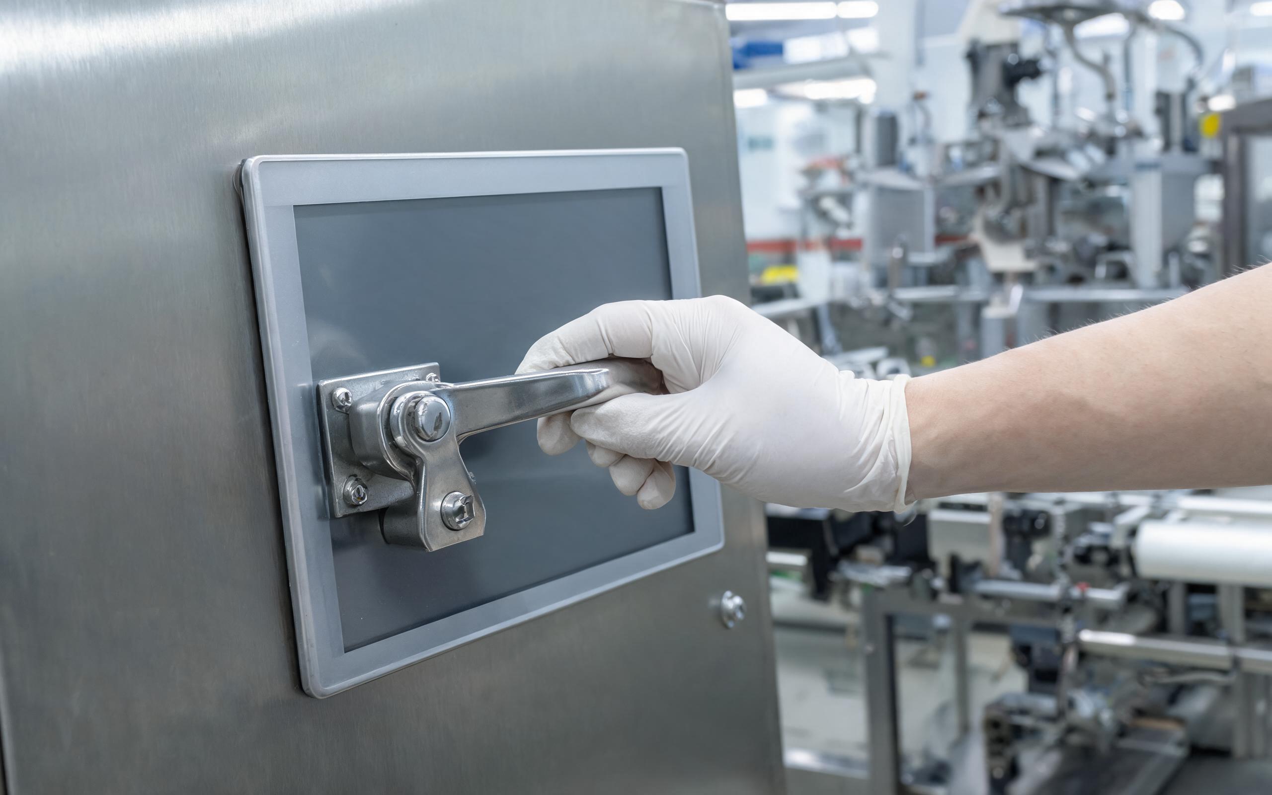 quick-release lever latch retaining an industrial panel mount monitor on a food packaging line cabinet